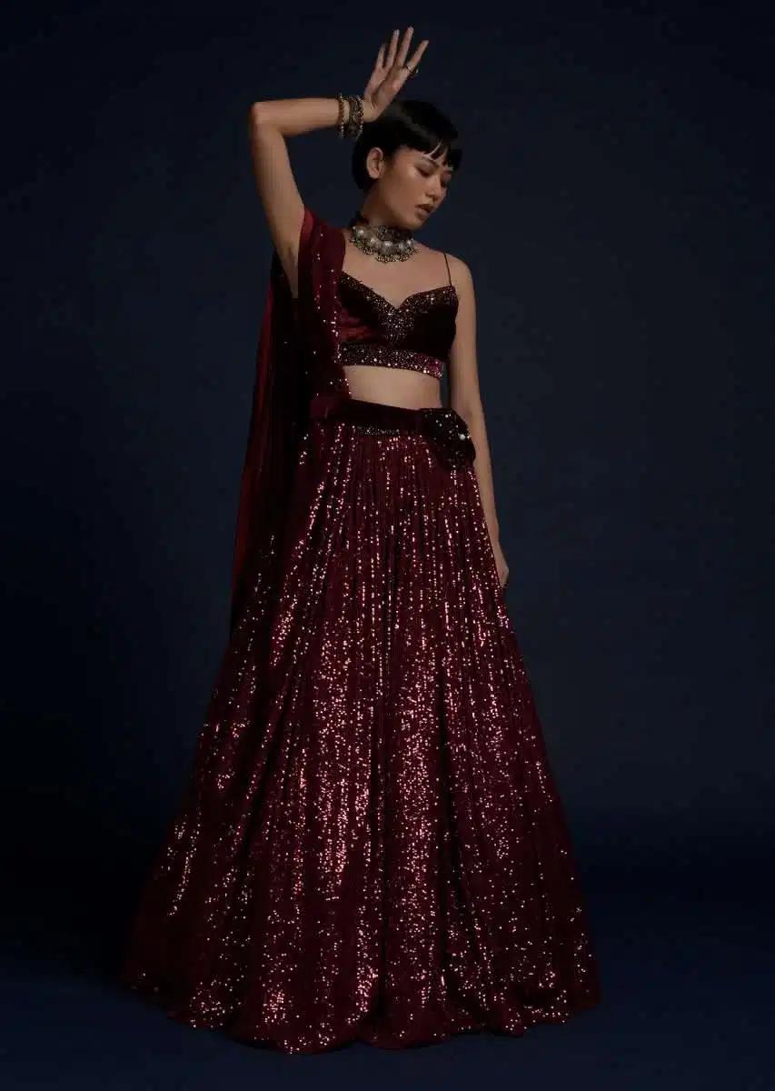 Burgundy Lehenga Skirt Embellished In Sequins Featuring A Velvet Crop Top Matching Belt Bag